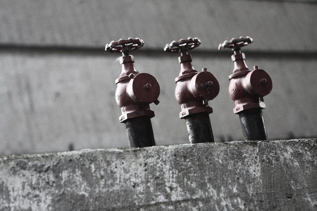Three industrial valves on a concrete wall, a technical product buyers research long before they call