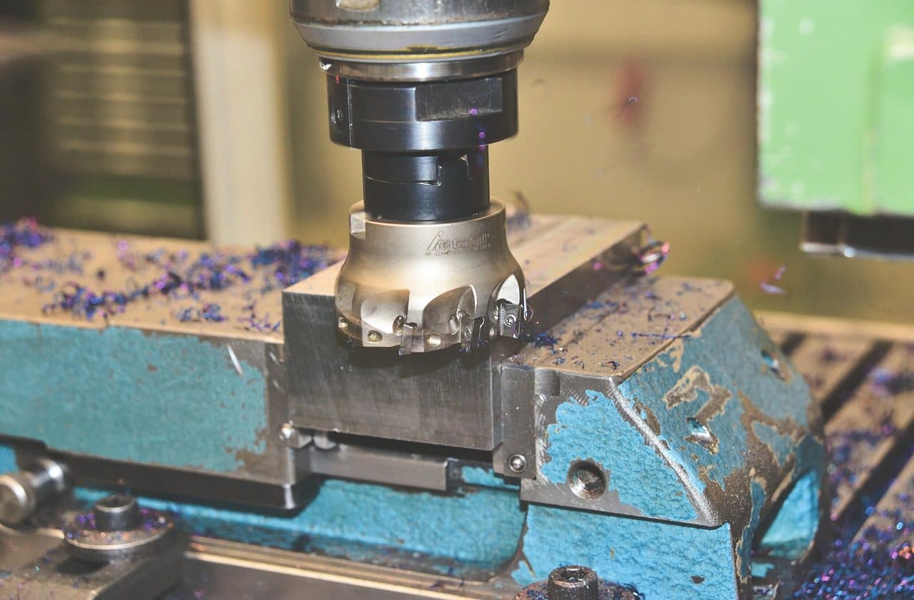 Milling cutter working a steel part with metal shavings, the kind of technical product manufacturers need to explain online
