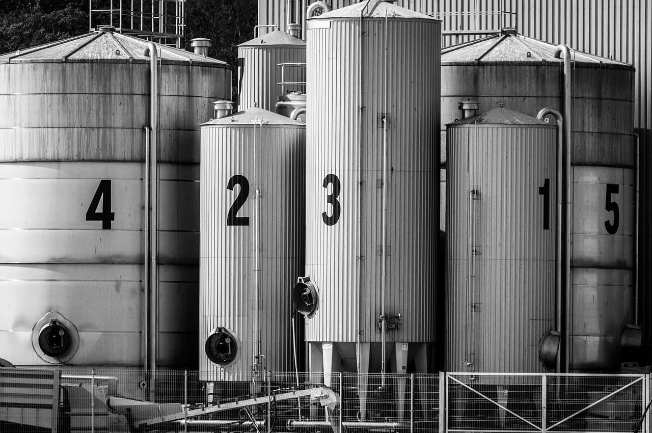 Row of numbered steel silos at an industrial site