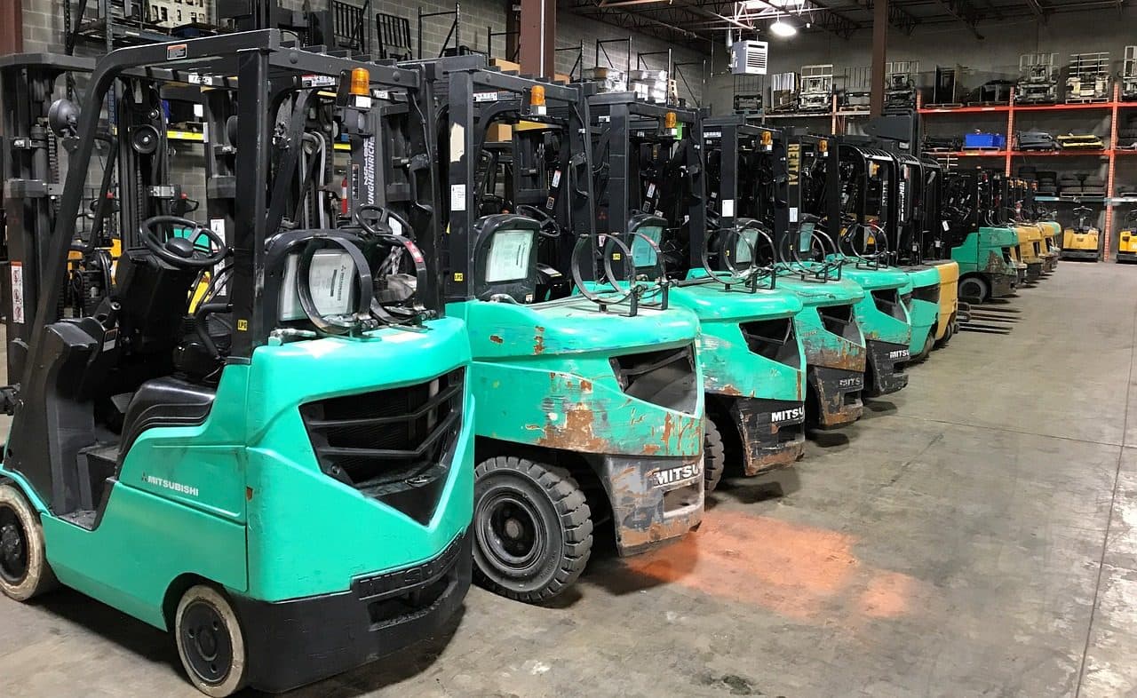 Row of forklifts parked in a factory hall