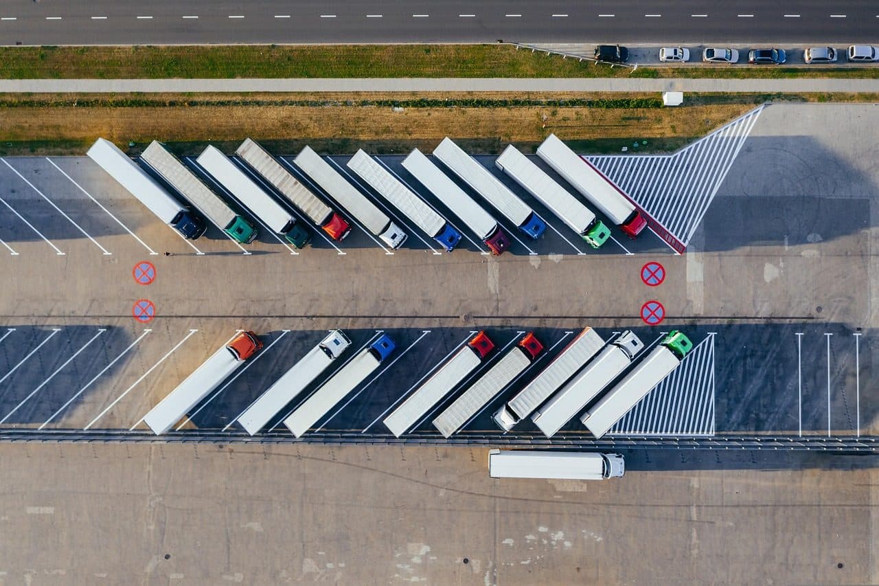 Aerial view of trucks lined up at a distribution depot, orders on their way once the plan works